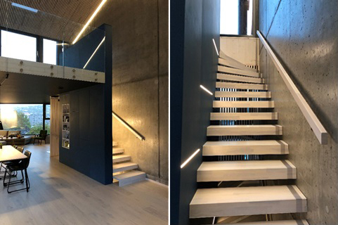 Trapp i betongbygg med innfelt LED-lysstripe langs vange og rekkverk