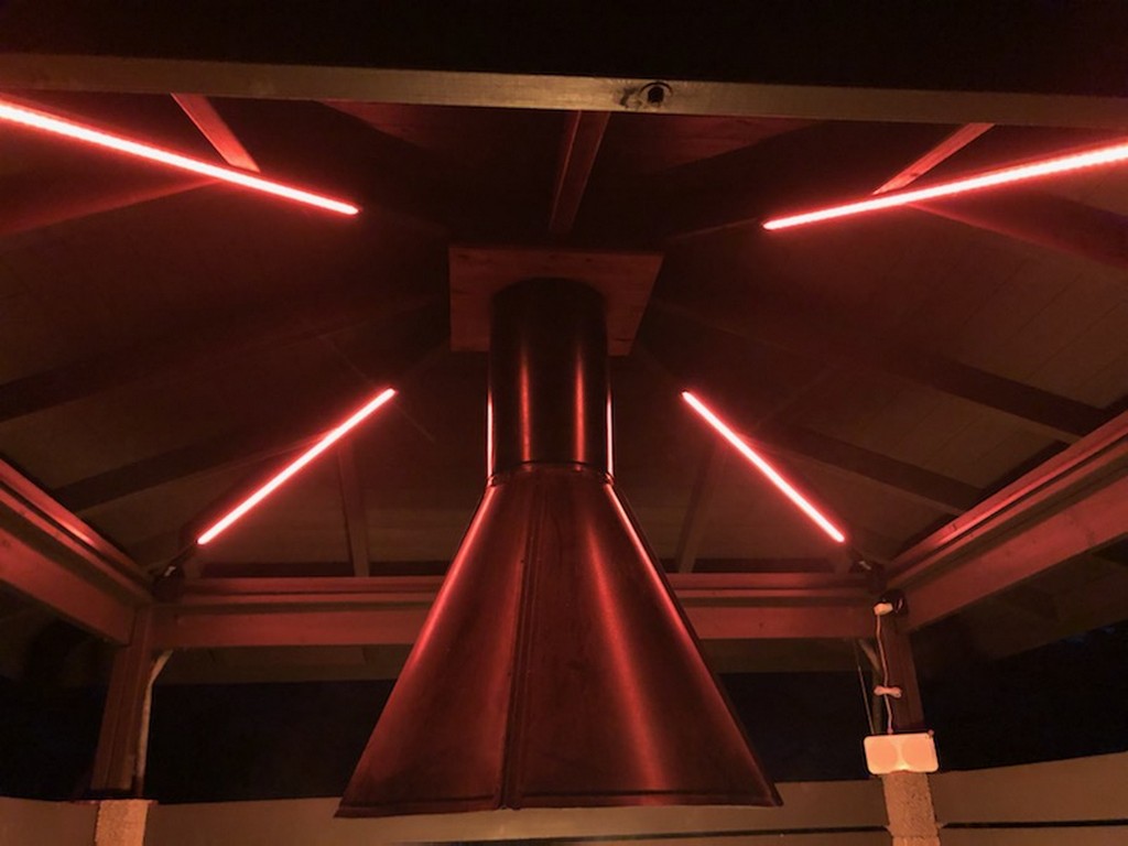 LED-stripes montert i taket på grillhytta, sett nedenfra mot pipa
